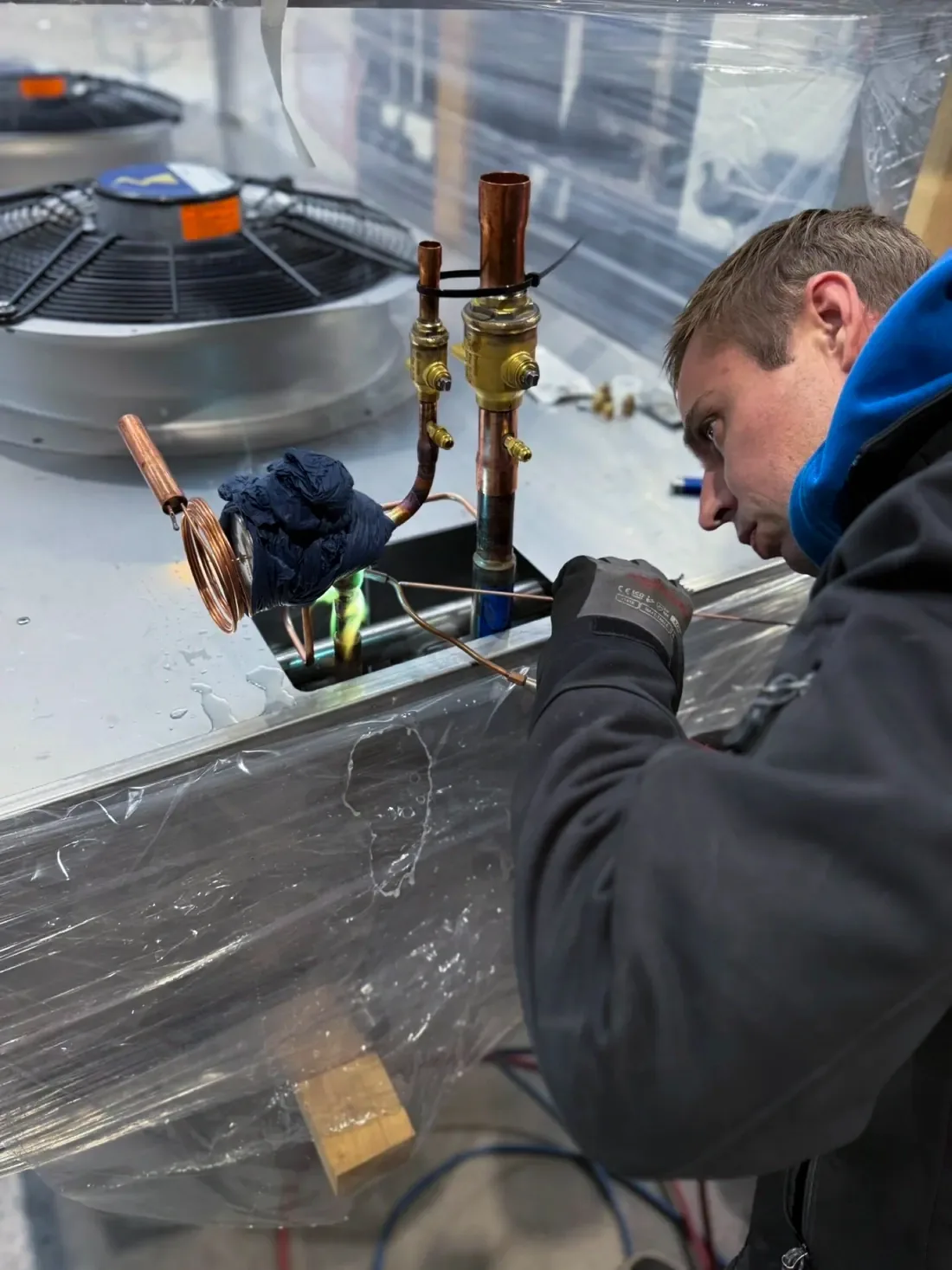 Technieker van Arec soldeert een koperleiding